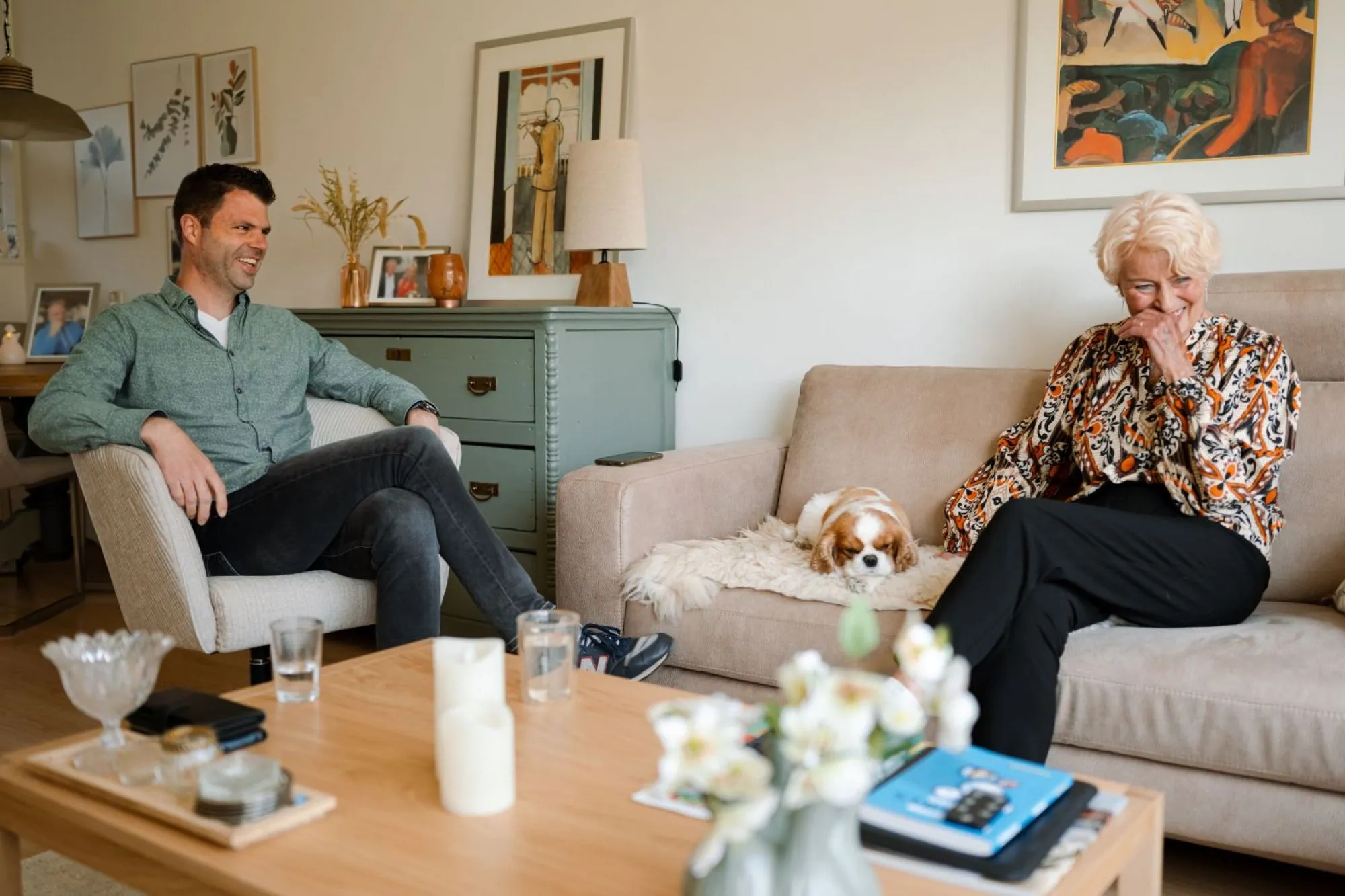 Thuiscoach samen op de bank met lachende seniore dame